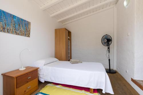 a white bedroom with a bed and a fan at Holiday Home - Son Vida in Mahón