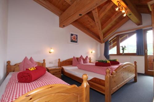 ニーダートハイにあるHaus Sonneckのベッドルーム1室(赤い枕のベッド2台付)