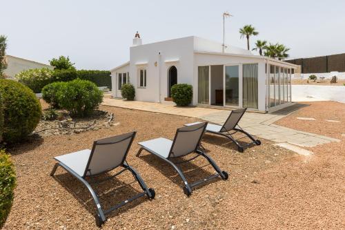 a couple of chairs sitting in front of a house at Holiday Home - Son Vida in Mahón