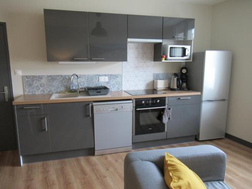 a kitchen with stainless steel appliances and gray cabinets at Forges 2 in Saujon