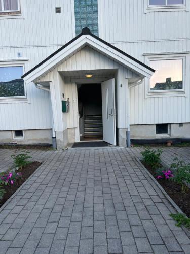 a white building with a door and a driveway at Åndalsnes gustehouse in Åndalsnes