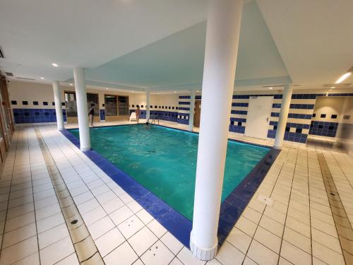 - une piscine dans un bâtiment avec colonnes dans l'établissement Appartement dans châlet avec piscine couverte, à Saint-Gervais-les-Bains