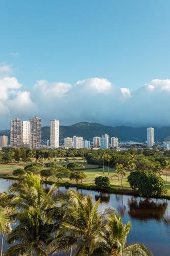 a view of a city with palm trees and a river at Wayfinder Waikiki - Voted Top 10 Best Hotels in Hawaii! in Honolulu