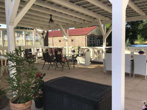 a patio with a table and chairs and a pergola at Gutshaus Darsikow in Darsikow