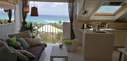 a living room with a couch and a view of the ocean at Boheme 4 personnes ( 2 chambres ) in Saint-François