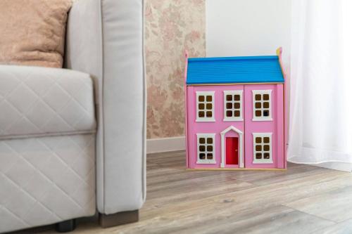 a toy house sitting on the floor next to a couch at Aszúvilág Rezidencia with Sauna & Jacuzzi in Legyesbénye