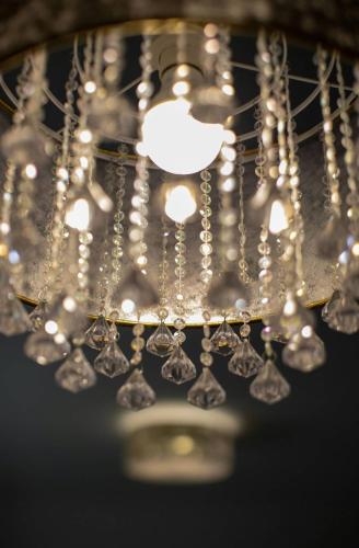 a close up of a chandelier with lights at Aszúvilág Rezidencia with Sauna & Jacuzzi in Legyesbénye