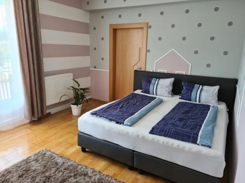 a bedroom with a large bed with blue pillows at Orchidea Apartment in Finkenstein