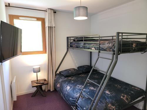 - une chambre avec 2 lits superposés et une télévision dans l'établissement Appartement dans châlet avec piscine couverte, à Saint-Gervais-les-Bains
