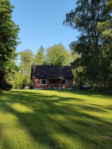 een huis midden in een groot grasveld bij Mysig villa i naturen in Glimåkra