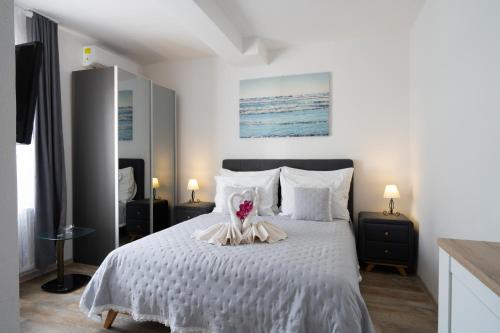 a bedroom with a white bed with a stuffed animal on it at Irene Bed & Breakfast Tisno in Tisno