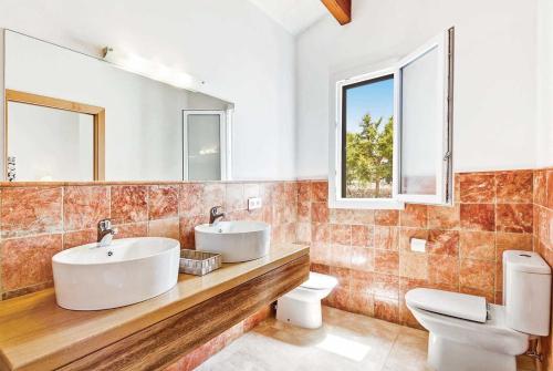 カラン・ボッシュにあるCamamil-Laのバスルーム(洗面台2台、トイレ、鏡付)