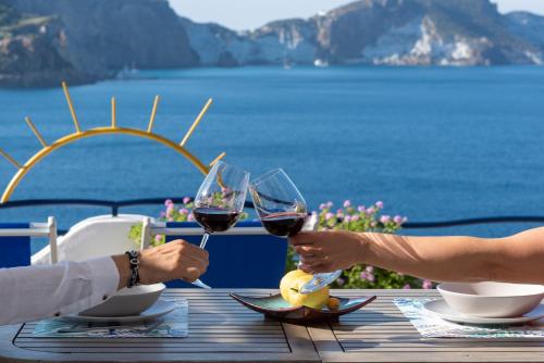 Maridea - Les Suites Du Soleil في بونسا: يجلس شخصان على طاولة مع أكواب من النبيذ