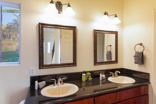 a bathroom with two sinks and two mirrors at Big Island Getaway, Ocean View Paradise in Ninole