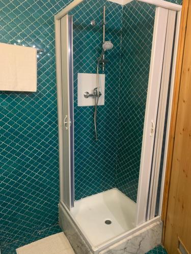 a bathroom with a shower with green tile at Le joli coin in Pila