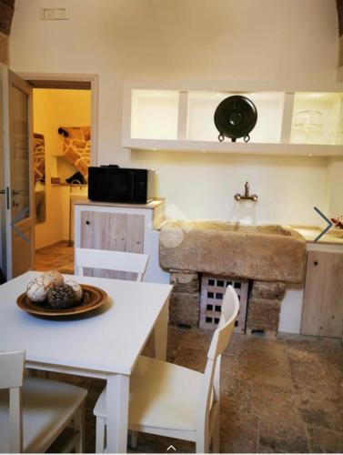 a kitchen with a table and a stone fireplace at Suite87 in Mesagne