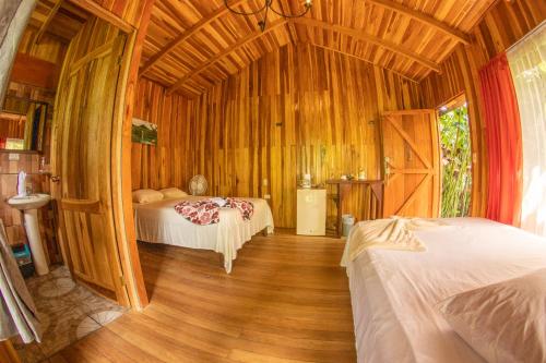a bedroom with two beds and a wooden ceiling at Arenal Rústic Lodge in Fortuna
