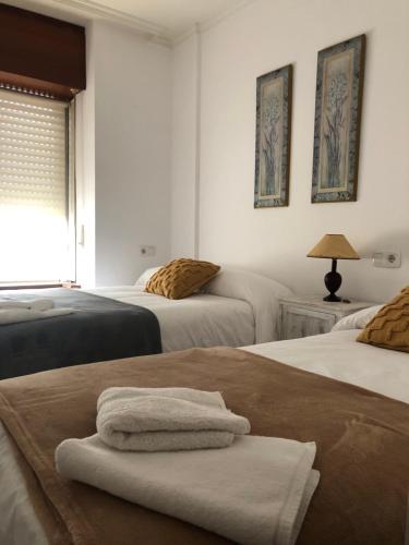a bedroom with two beds with towels on them at Raquel in Arzúa
