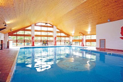 a large swimming pool in a large building at Bowness 45 - 2 bedroom Lake Windermere Lodge in Windermere