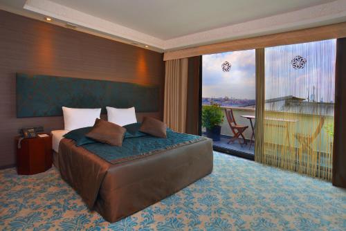 1 dormitorio con 1 cama grande y balcón en Pera Tulip Hotel, en Estambul