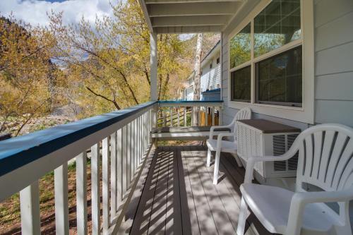 a porch with two chairs and a table on it at Twin Peaks Lodge & Hot Springs in Ouray