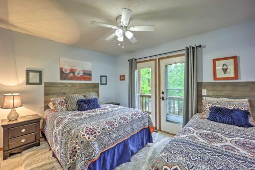 a bedroom with two beds and a ceiling fan at Waterfront Home on Beaver Lake with 2 Decks! in Garfield