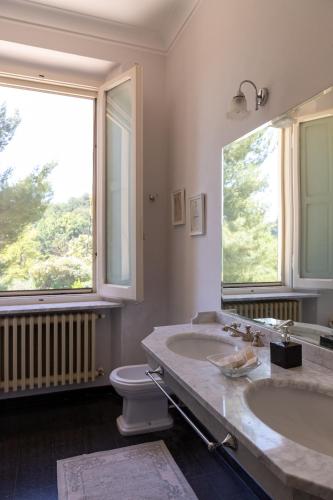 a bathroom with two sinks and a toilet and a window at Villa Monacelli in Fano