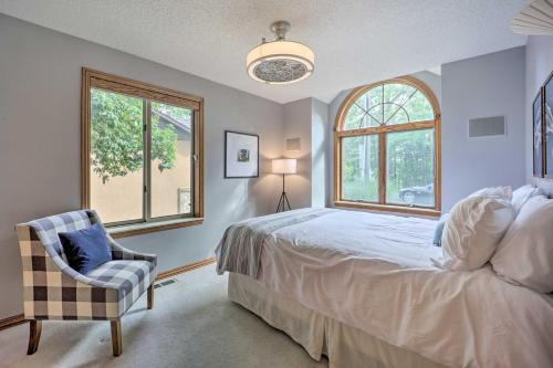 een slaapkamer met een bed, een stoel en ramen bij Spacious Beaver Lake Home with Stunning Views! in Garfield