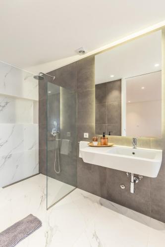 a bathroom with a sink and a shower at Casa 141- familiar conforto paz e bem-estar in Guimarães