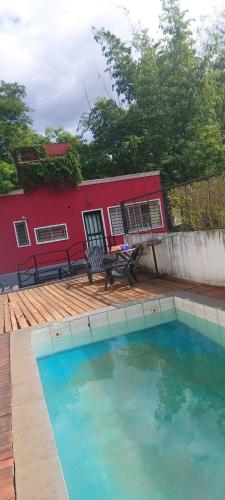 una piscina frente a una casa roja en Wonderful en Puerto Iguazú