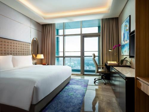 a hotel room with a bed and a desk and window at InterContinental Hotels Jakarta Pondok Indah by IHG in Jakarta