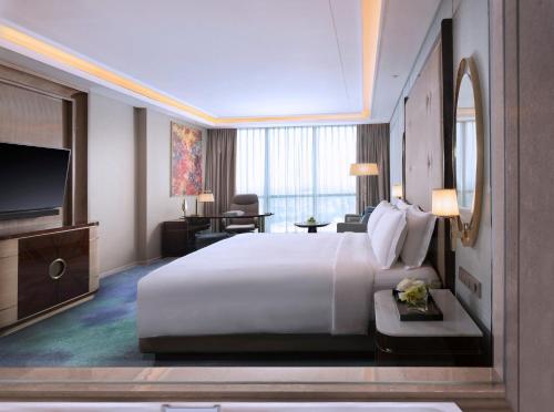 a hotel room with a large bed and a television at InterContinental Hotels Jakarta Pondok Indah by IHG in Jakarta
