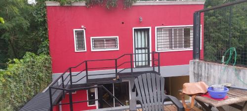 una casa roja con una escalera delante de ella en Wonderful en Puerto Iguazú