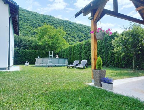 a yard with two lounge chairs and a house at Luxury house "Heart of Nature" Visoko in Visoko