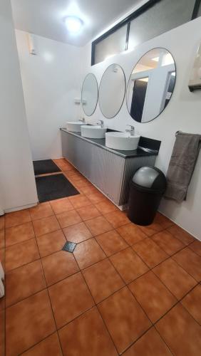 a bathroom with two sinks and two mirrors at Happy Apple Backpackers in Motueka