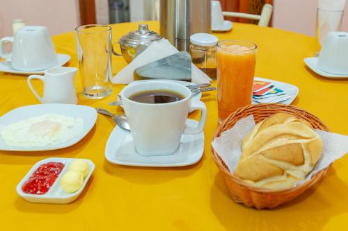 a table with a cup of coffee and a basket of bread at Hotel Musuk Wasi in Arequipa