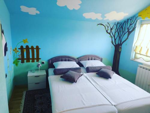 a bedroom with two beds with a tree on the wall at Luxury house "Heart of Nature" Visoko in Visoko