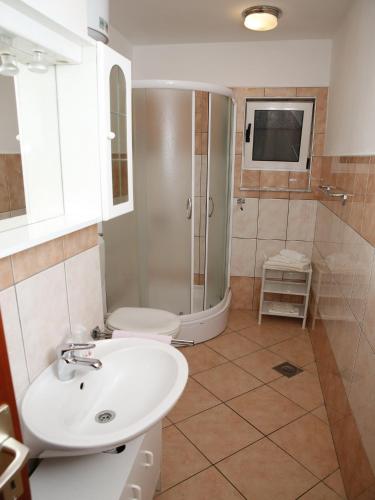 a bathroom with a sink and a shower at Apartments M&R ŠPADINA in Vodice