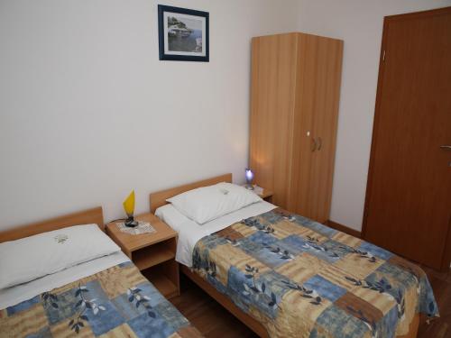 - une chambre avec 2 lits et une armoire en bois dans l'établissement Apartments M&R ŠPADINA, à Vodice