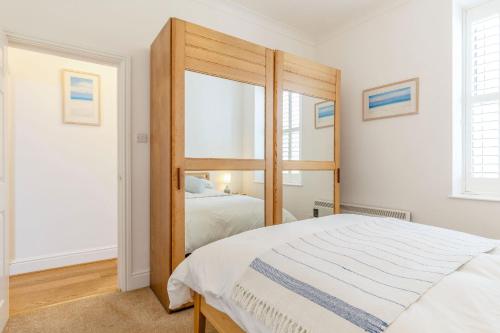 1 dormitorio con espejo grande junto a la cama en Apartment 1 Llewellan, en Carbis Bay