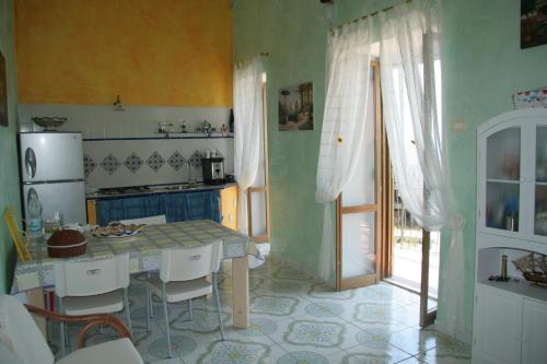 a kitchen with a table and a refrigerator at B&B Borgo Marinaro in Pozzuoli