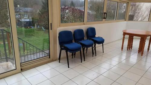 Zimmer mit vier blauen Stühlen und einem Tisch in der Unterkunft chez anita in Magny-en-Vexin