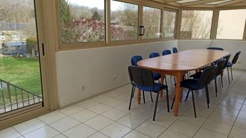 una sala de conferencias con mesa de madera y sillas en chez anita, en Magny-en-Vexin