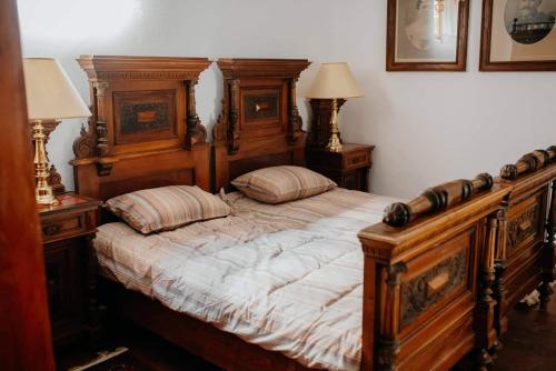 een slaapkamer met een groot houten bed met 2 kussens bij Kuća za odmor "Šokačka lady" in Županja