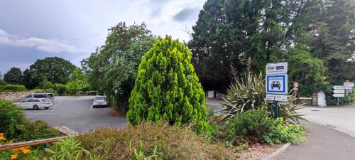 a parking lot with a car parked next to a tree at Chambre chez l'habitante "Bambou" in Derval