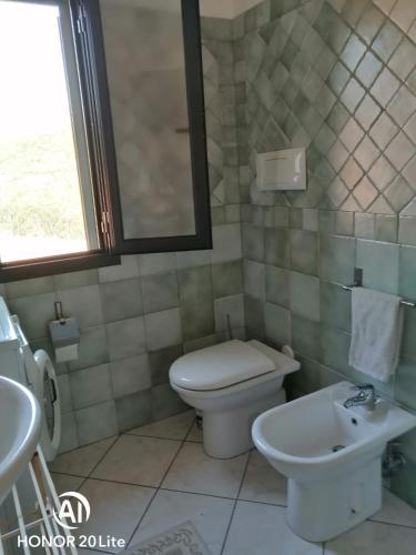 a bathroom with a toilet and a sink at Casa Giulia in San Teodoro