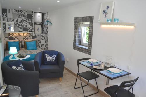ein Wohnzimmer mit einem blauen Stuhl und einem Tisch in der Unterkunft Alfama Lisbon Studio in Lissabon