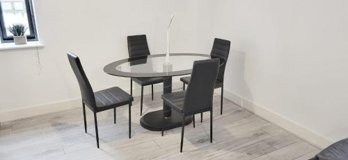 mesa de comedor y 4 sillas negras en City Centre 1 Bed Apartment en Birmingham