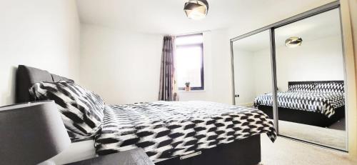 a bedroom with a black and white bed and a mirror at City Centre 1 Bed Apartment in Birmingham