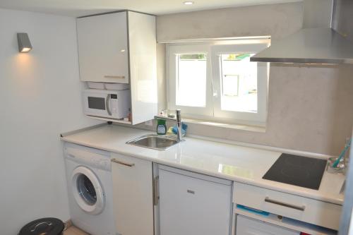 a kitchen with a sink and a washing machine at Alfama Lisbon Studio in Lisbon